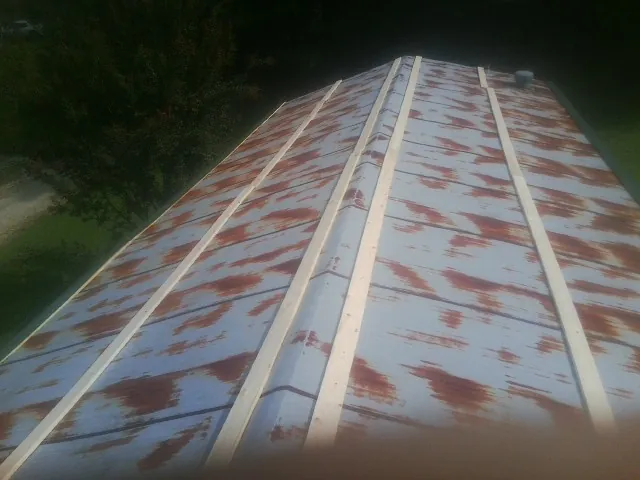 Rusted metal roof panels with new wood purlins before replacement — Storm Damage Roof Repair in Newdale by Roofing Brothers