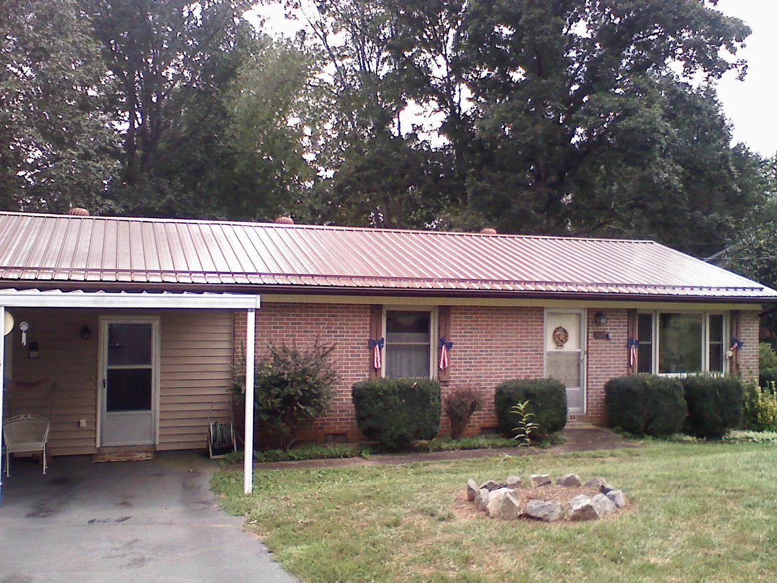 Bronze metal roof and carport on a brick ranch home — Roof Repair work by our crew in Newdale